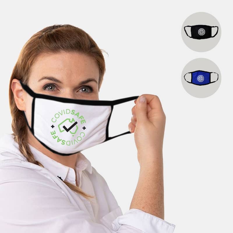 A woman holds a white cotton face mask featuring a logo, with black and navy masks displayed beside her.