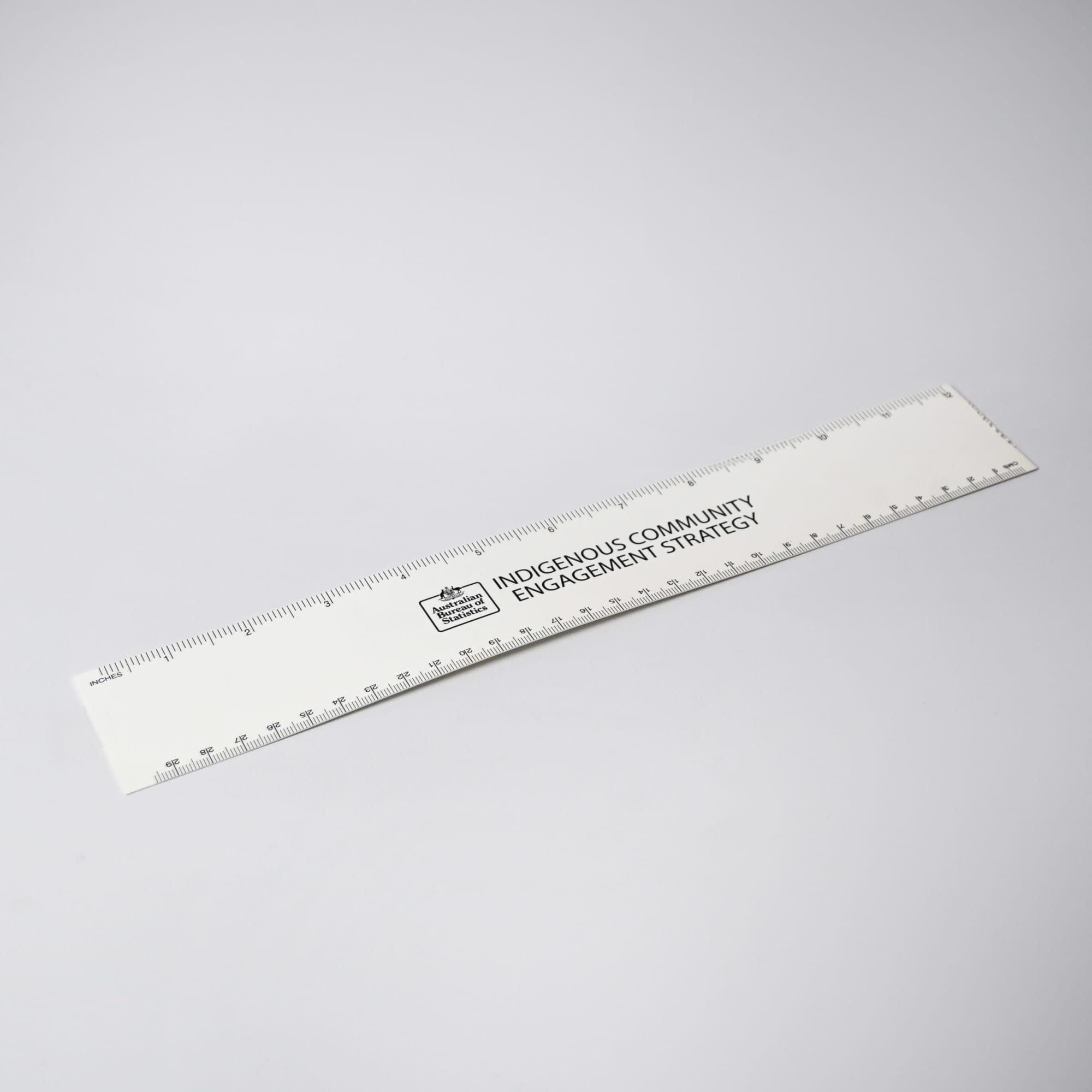 A white ruler with markings and a logo, designed for office and business use.