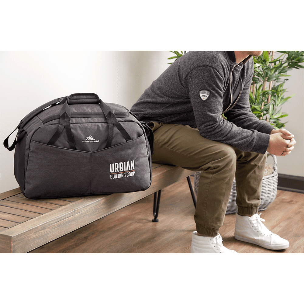 A large, dark grey duffel bag with dual handles and a removable shoulder strap, featuring a logo.