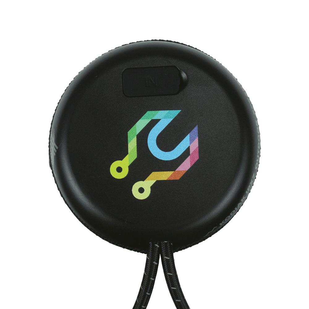A black outdoor Bluetooth speaker held above a charging pad, featuring a textured finish and a carrying strap.