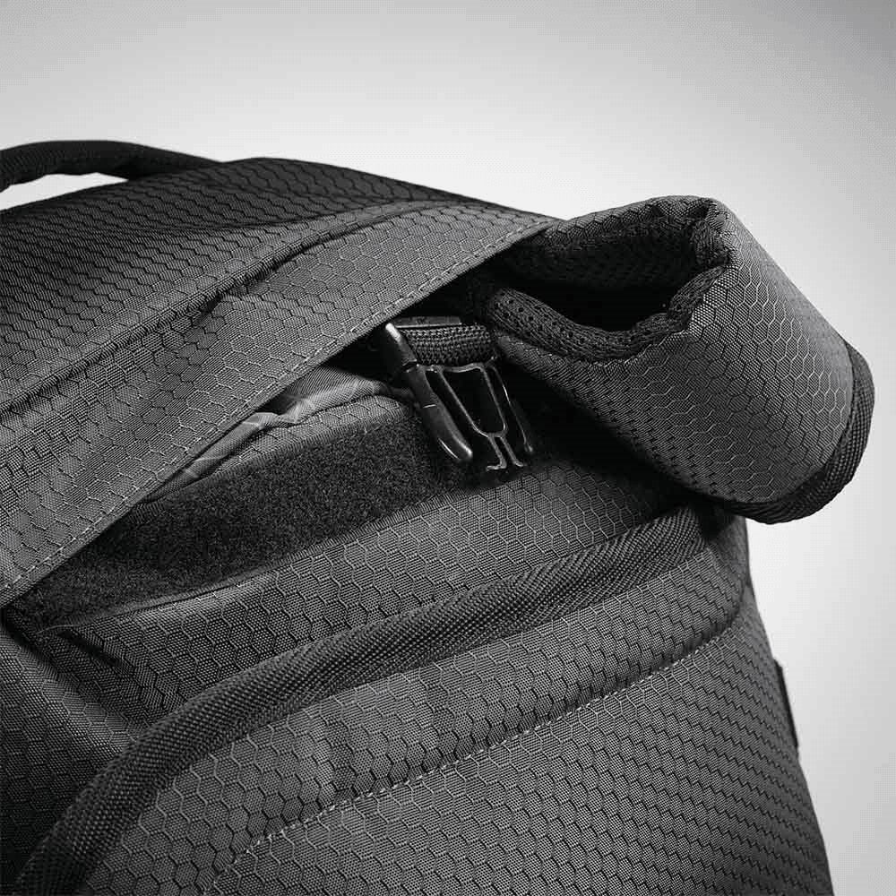 A black duffel backpack with a textured fabric and zippered opening, featuring padded shoulder straps.