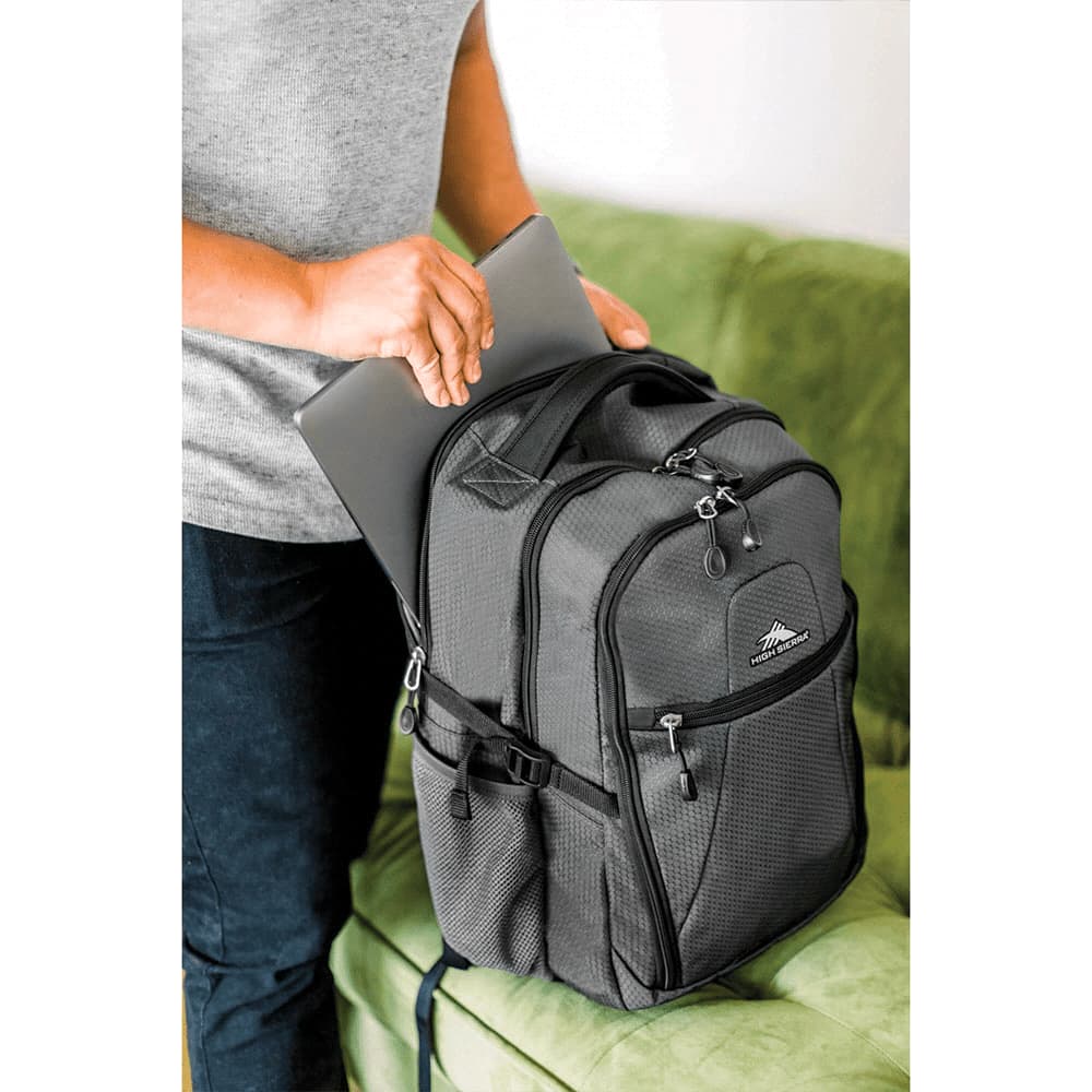 A grey 32L computer backpack with multiple compartments, being used to store a laptop. It has a logo on the front.