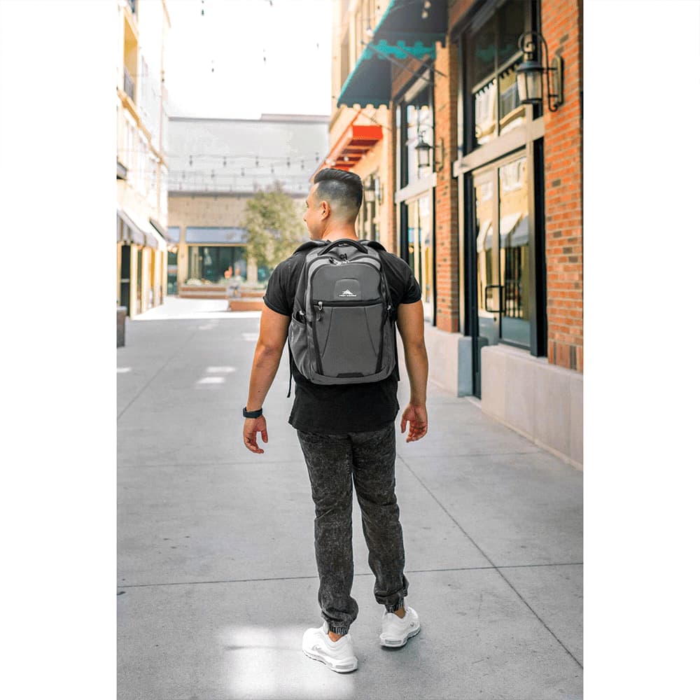 A person walks in a shopping area wearing a grey High Sierra Fairlead 15