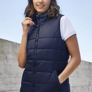 A navy women's alpine vest with a zip front, styled with a white t-shirt underneath, and featuring side pockets.