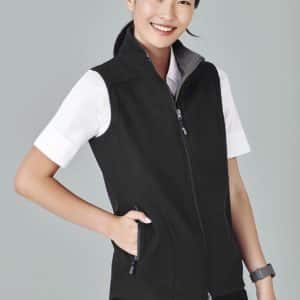 A black women's vest with a zip front, featuring a grey collar and side pockets, worn over a white shirt.