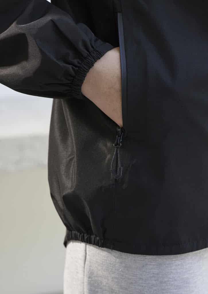 A black women's rain jacket featuring elastic cuffs and a zippered pocket on the side.