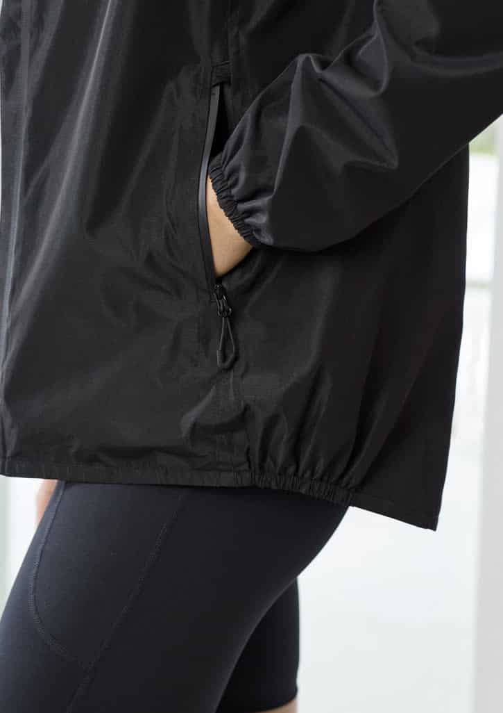 A black women's rain jacket features elastic cuffs and a side pocket, designed for comfort and style.
