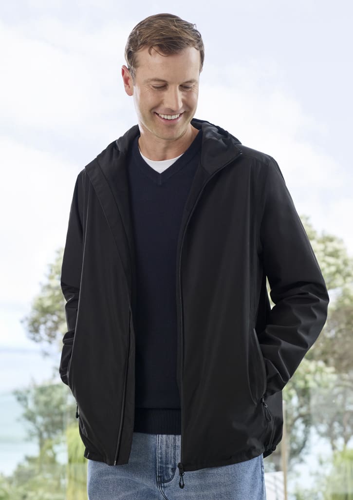 A black rain jacket with a hood, featuring side pockets and a logo, worn by a man smiling outdoors.