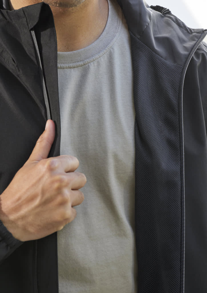 A men's black rain jacket with a grey shirt underneath, featuring a logo on the front.