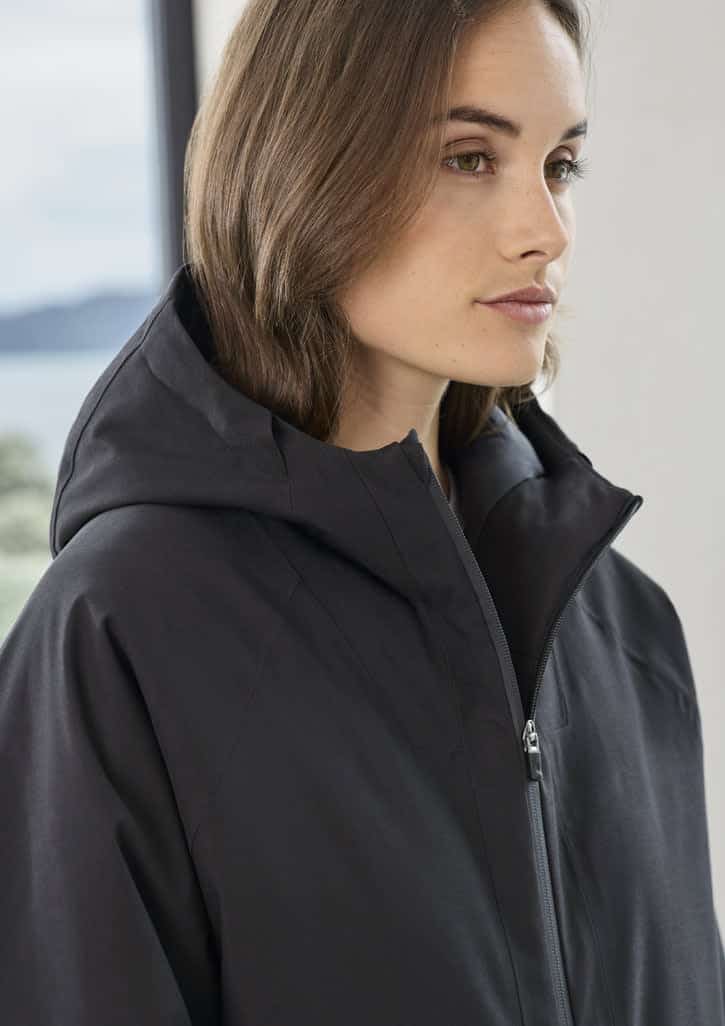 A unisex black rain jacket with a hood, featuring a sleek design and a subtle logo.
