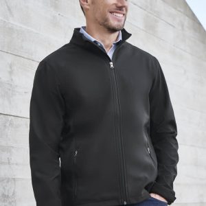 A black soft shell jacket featuring a zip front and side pockets, worn by a smiling man against a textured background.