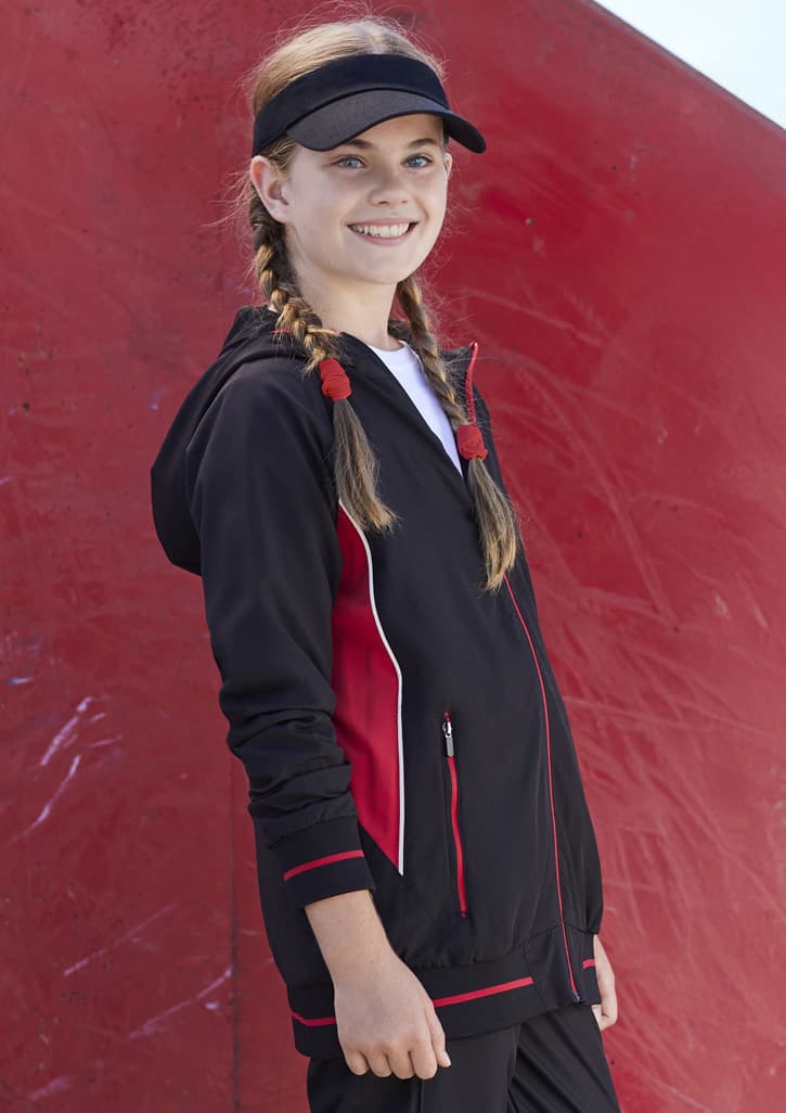 A black and red soft shell jacket worn by a young girl, featuring a hood and zippered pockets.
