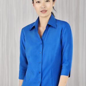 A blue ladies' shirt with 3/4 sleeves, featuring a collar and button-down front. Includes a logo.