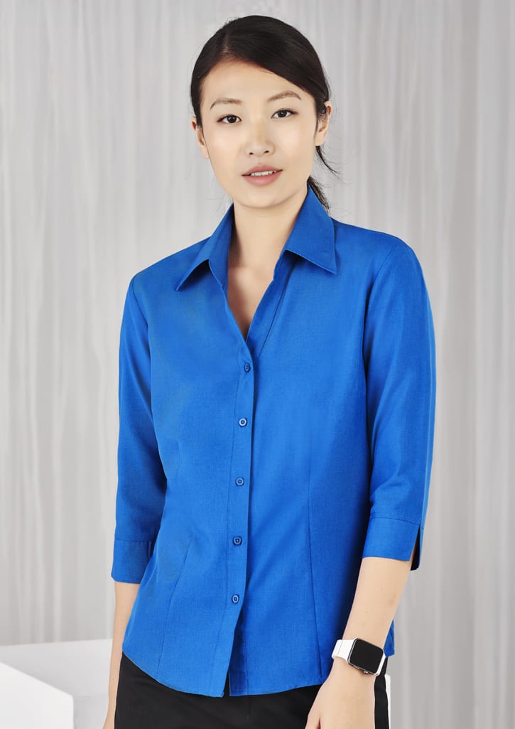 A blue ladies' shirt with 3/4 sleeves, featuring a collar and button-down front. Includes a logo.