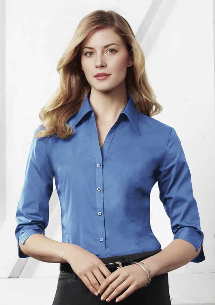A women's button-up shirt in a vibrant blue colour with 3/4 sleeves and a fitted style, featuring a logo.