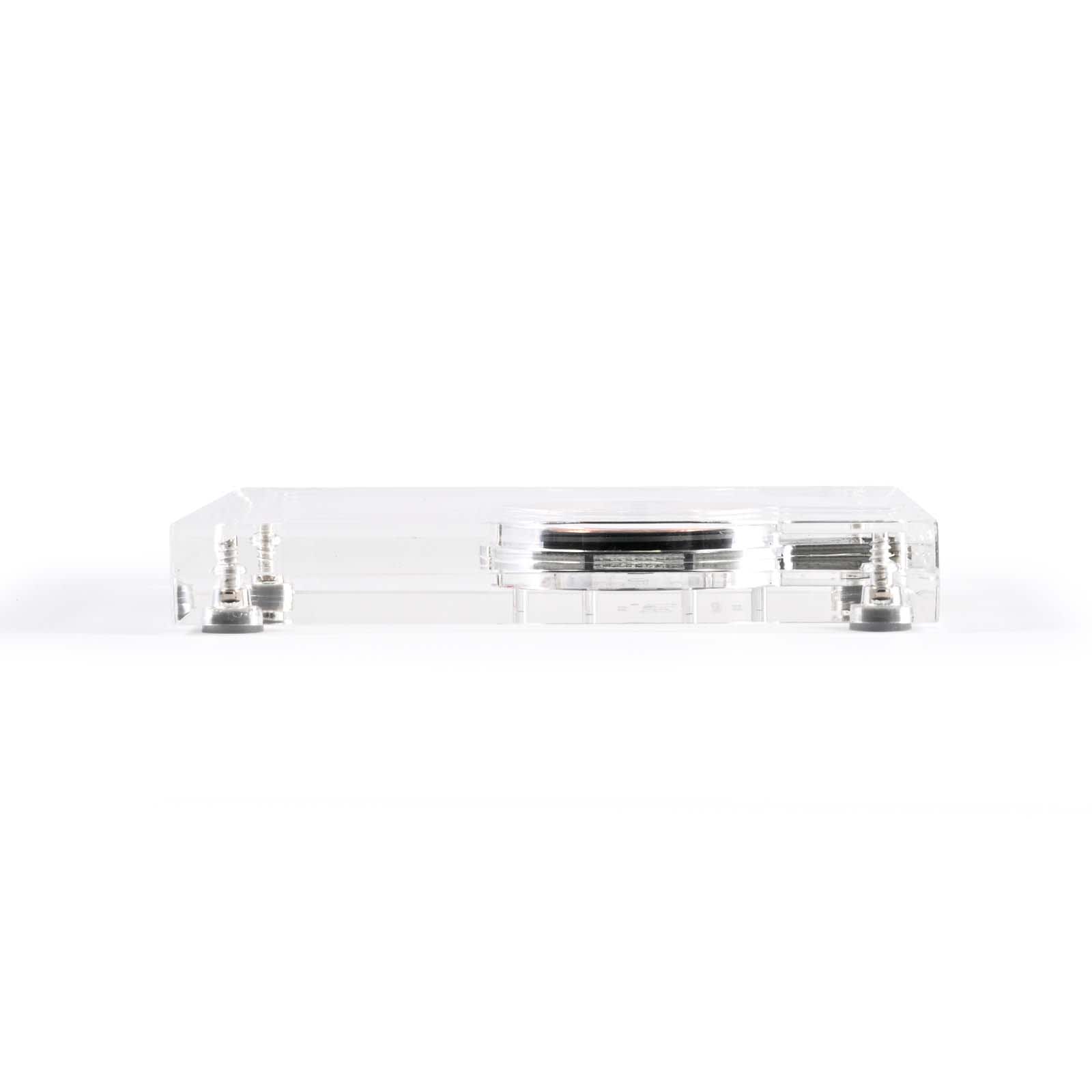 A clear crystal wireless charger with a sleek design and metallic accents. It features a logo on the surface.
