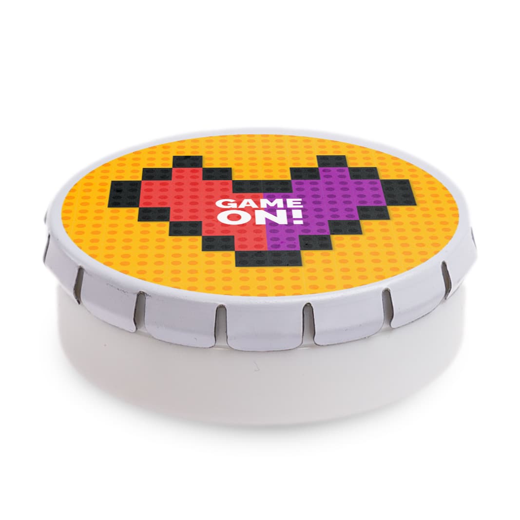 A round mint tin with a colorful pixelated heart design in red and purple on a yellow background.