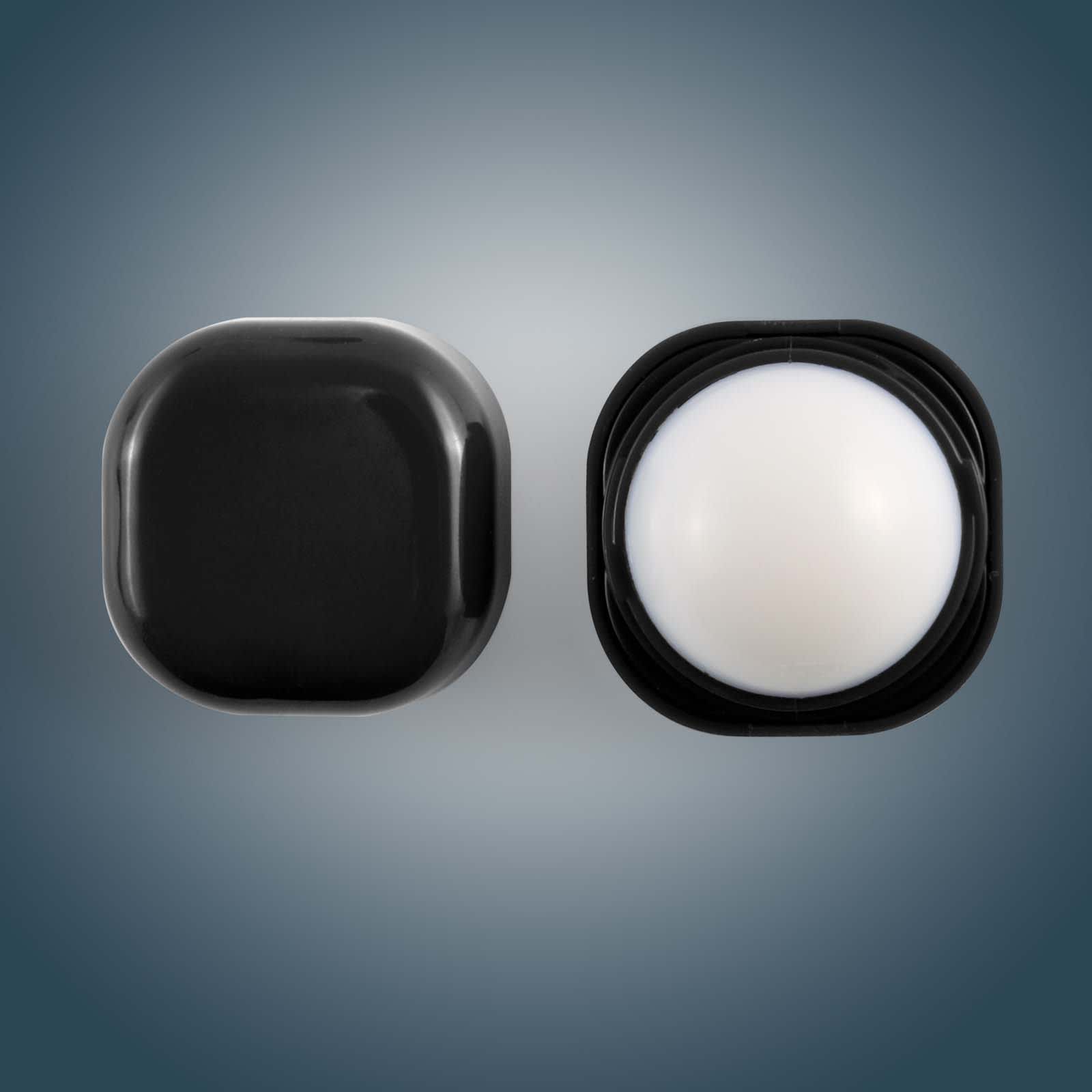 A Cube Lip Balm in a sleek black container, featuring a rounded lip balm interior.