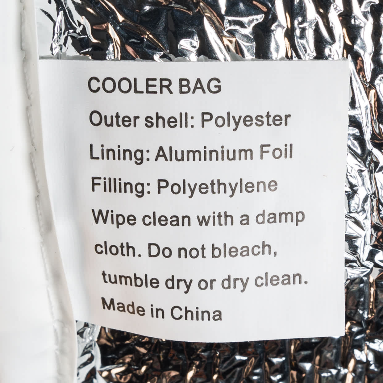 A cooler bag with a zippered closure. The bag is predominantly white with a black zipper.