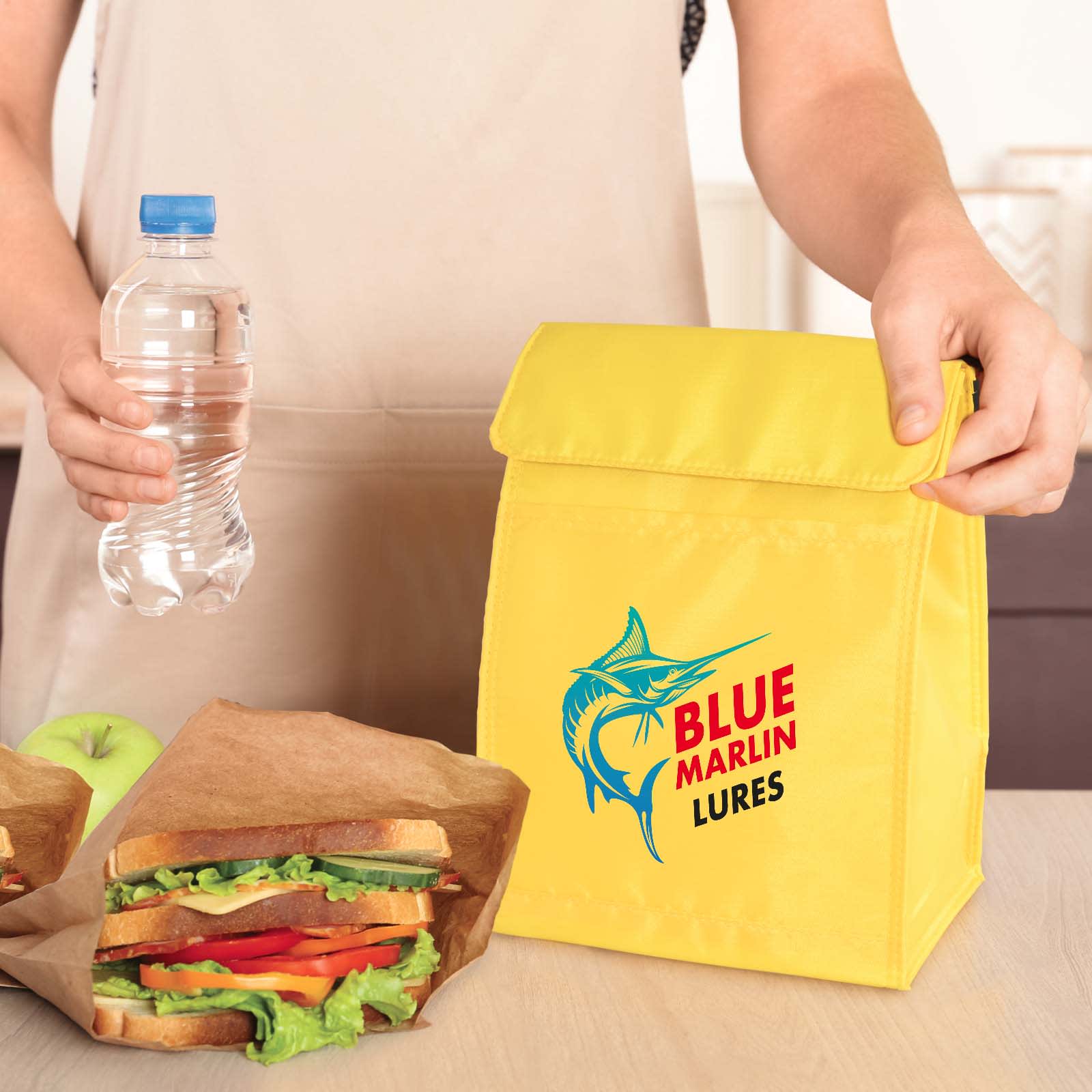 A yellow cooler lunch bag with a logo, accompanied by a drink bottle and two sandwiches in brown paper.