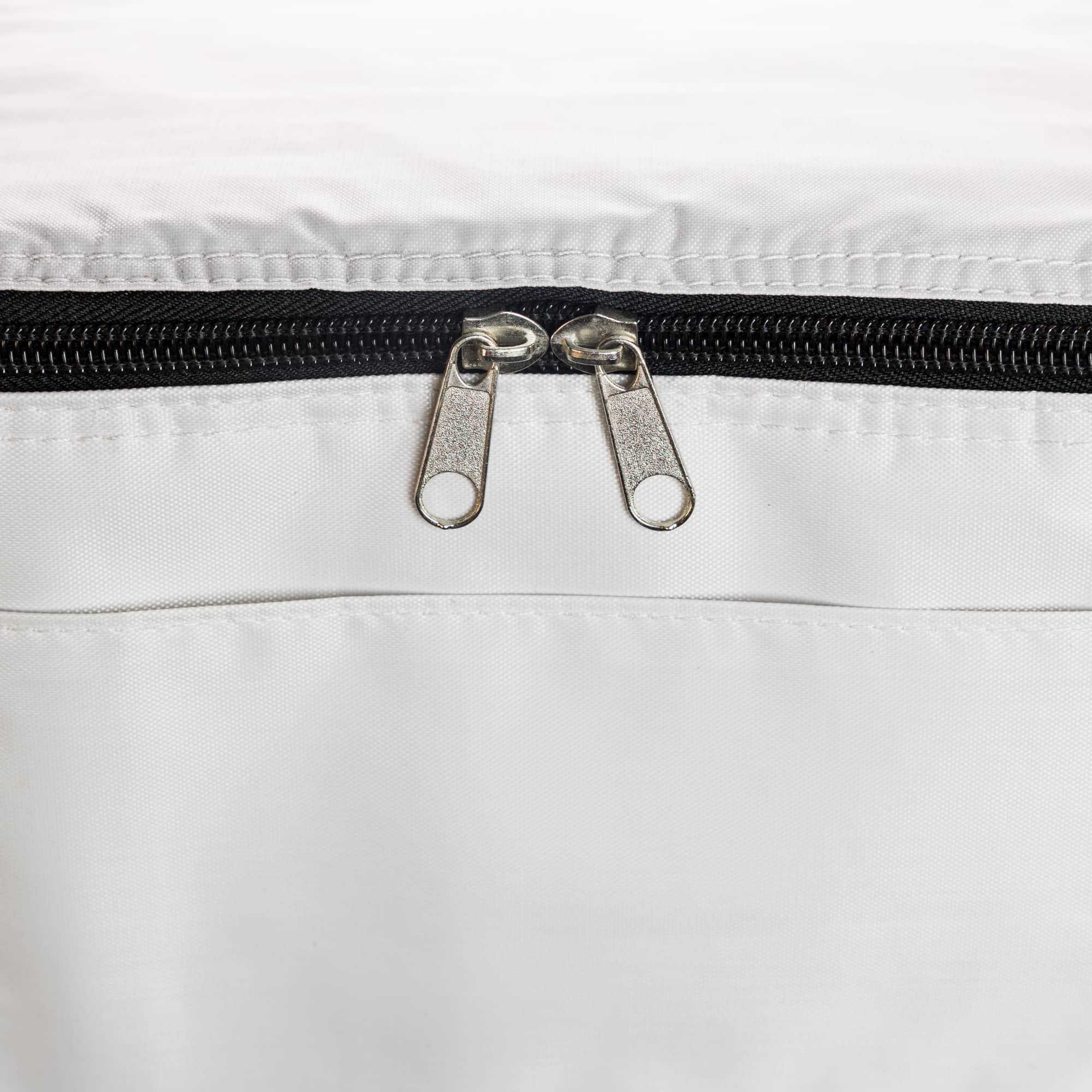 A cooler bag in light grey with a reflective silver interior and a zippered opening. It has a simple design and no visible branding.