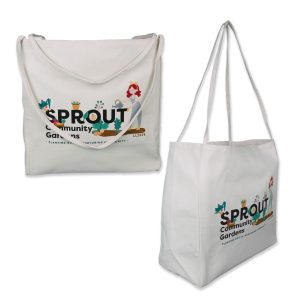 A beige tote bag with long handles, carried by a person, features a minimalist design and a logo.