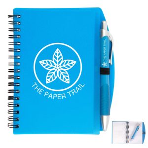 A blue spiral notebook with a pen attached, featuring a logo on the cover.