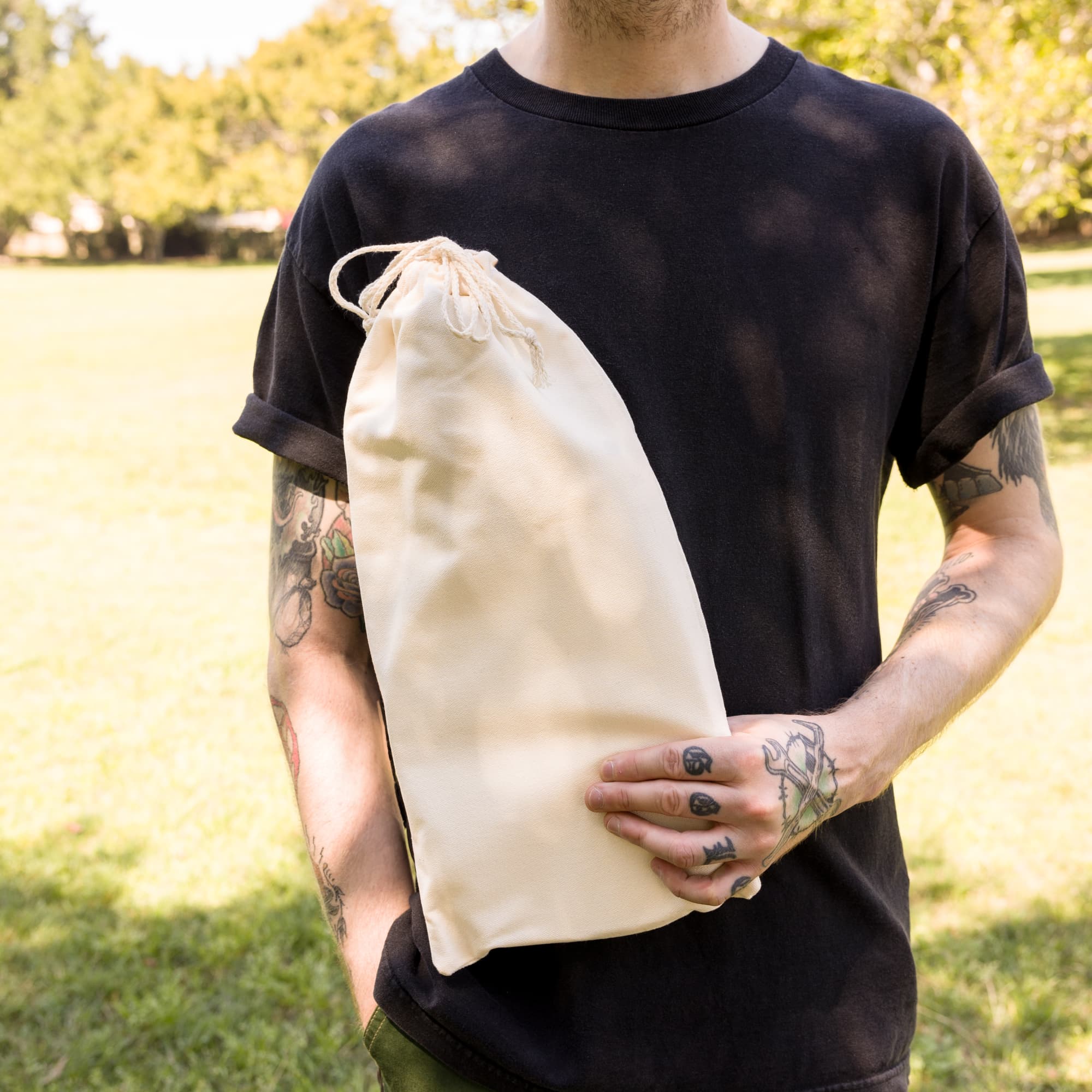 A beige carrying case for a pickleball set, held by a person wearing a black t-shirt.