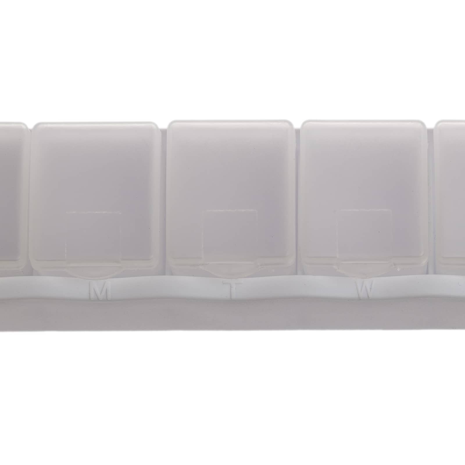A weekly pill box in translucent white plastic with compartments labeled for each day of the week.