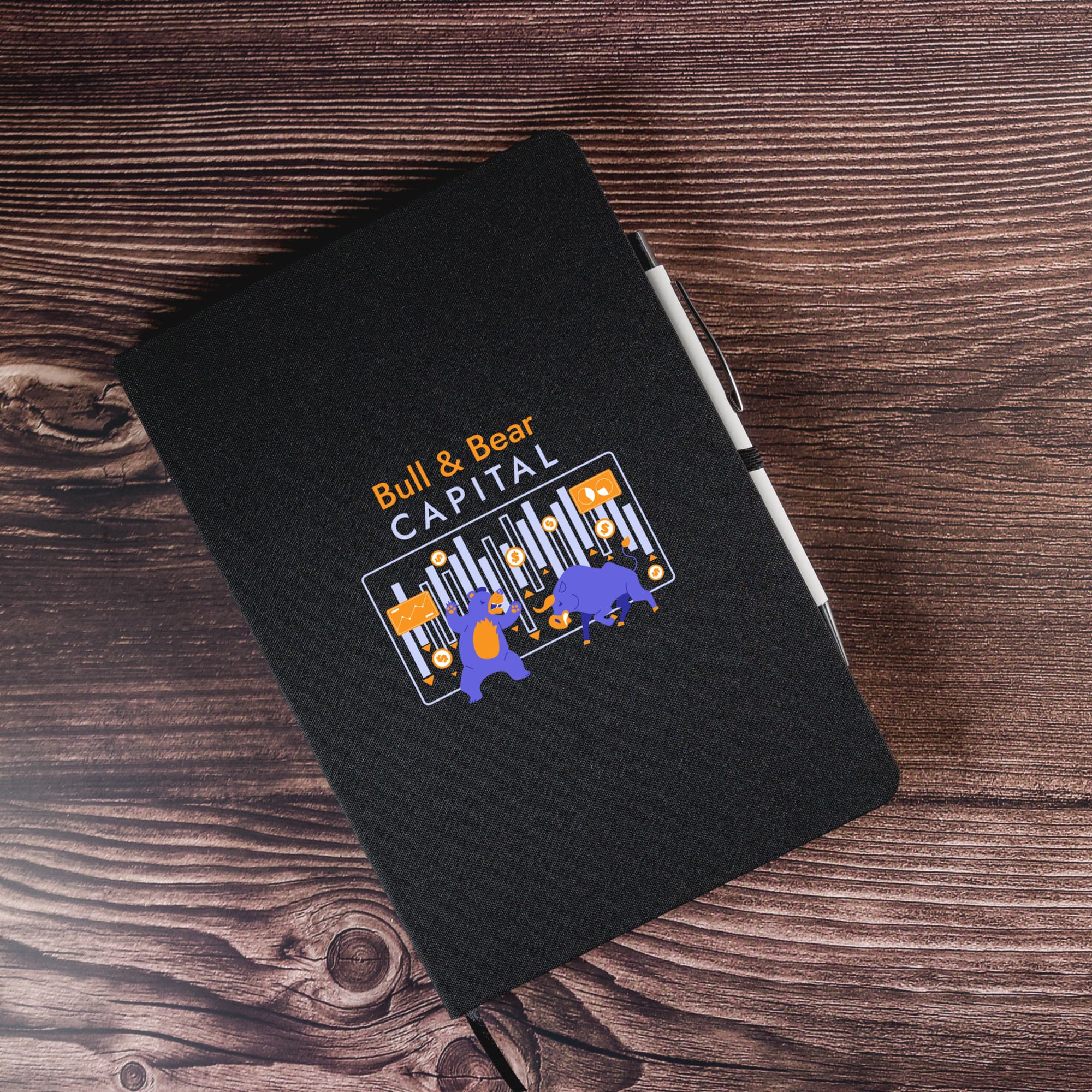 A black A5 notebook with an illustration on the cover and a white pen beside it.
