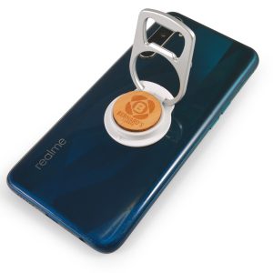 A drink bottle opener attached to a phone, featuring a silver opener and a circular wooden base on a dark blue phone.