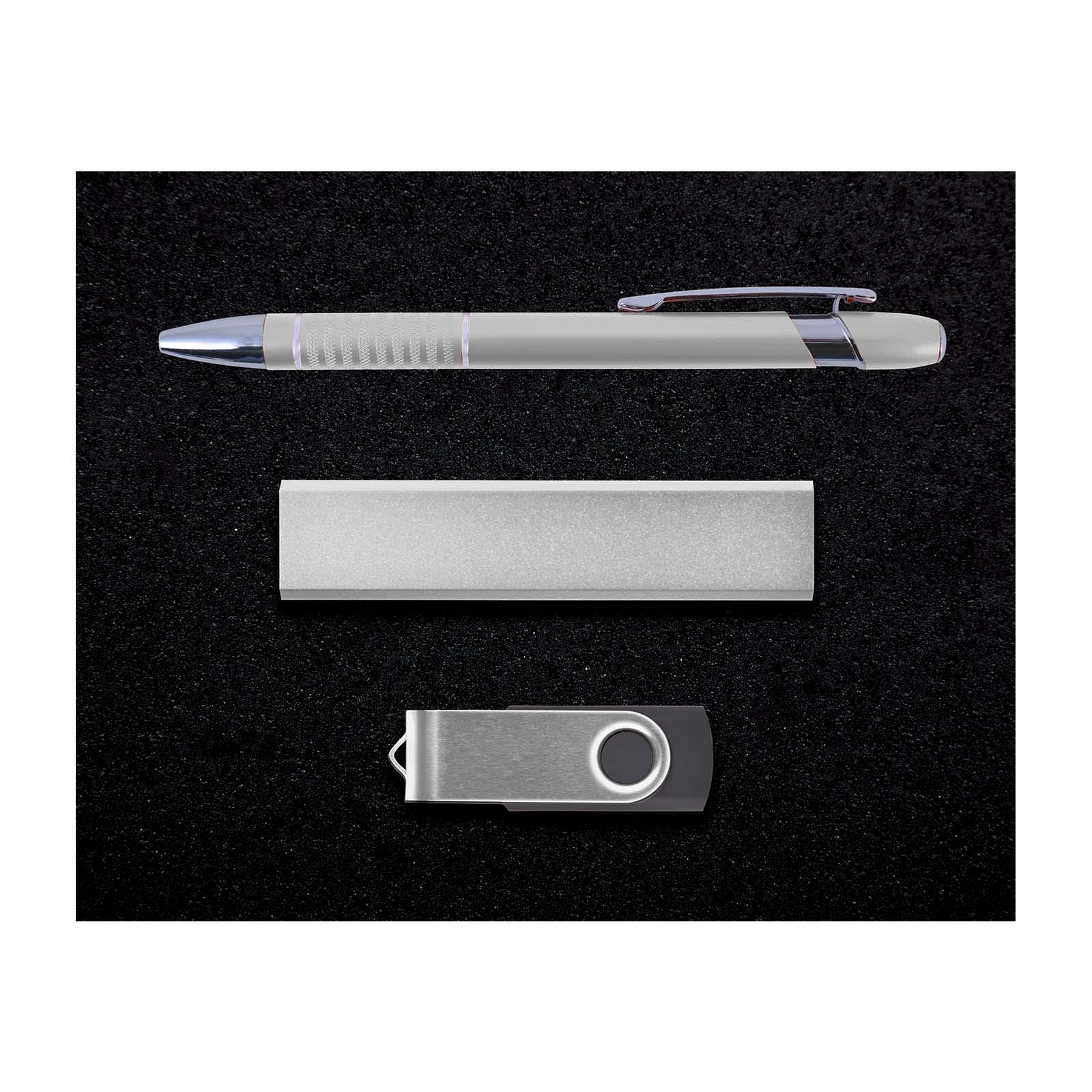 A sleek silver pen, a metallic flash drive, and a polished metal nameplate are arranged in a neatly organized set.