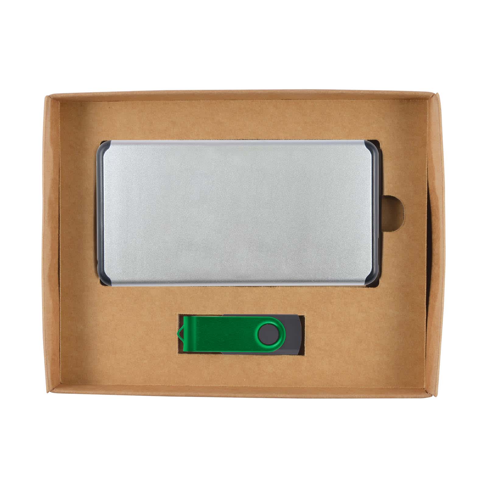 A silver power bank and a green USB drive inside a brown cardboard gift box. The box has a logo.