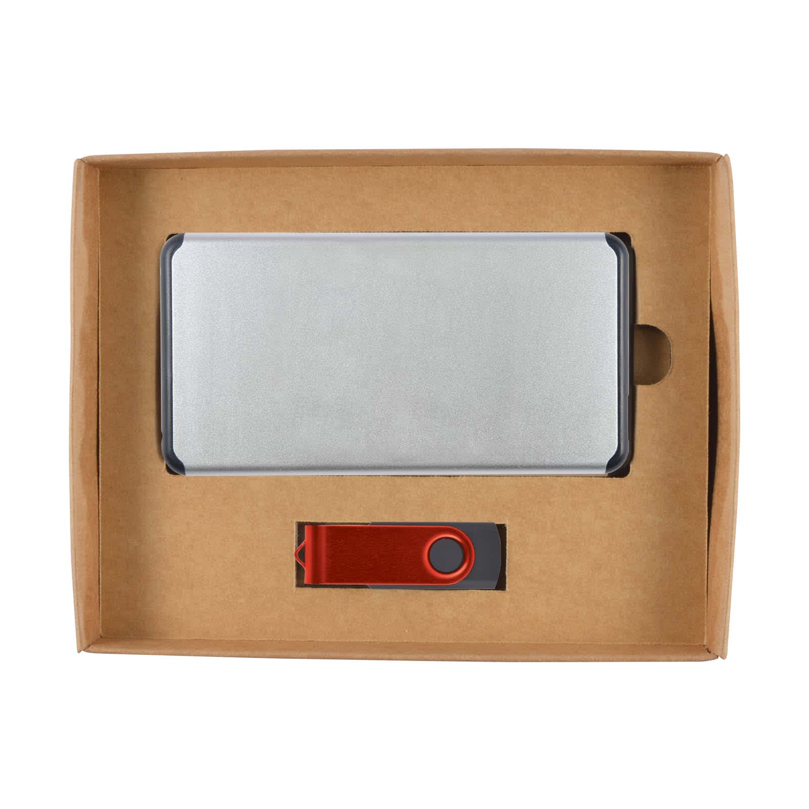 A cardboard gift set containing a silver power bank and a red USB flash drive.