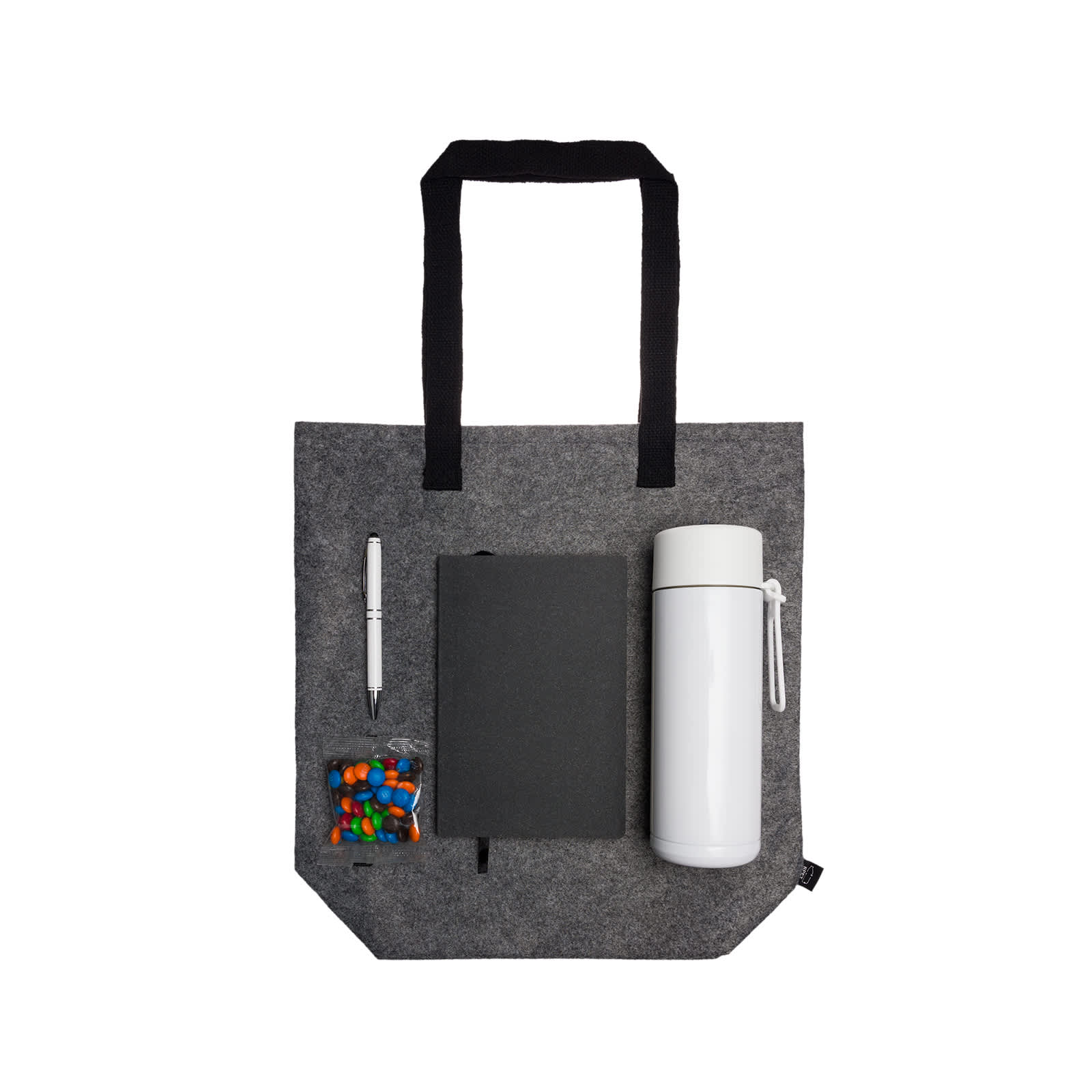 A gray tote bag containing a drink bottle, a notebook, a pen, and a small bag of candies.