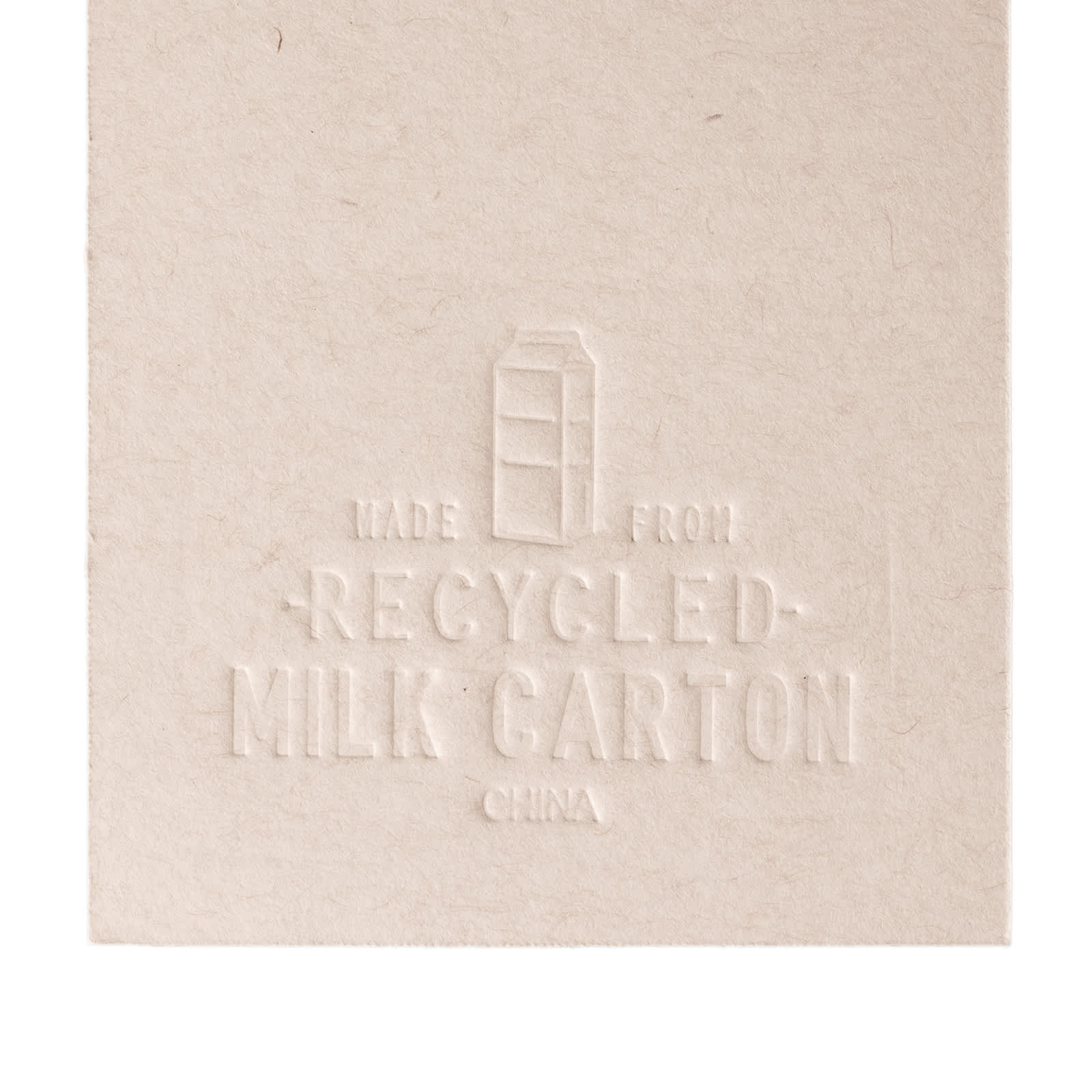 A booklet made from recycled milk cartons, featuring an embossed design that highlights its eco-friendly material.