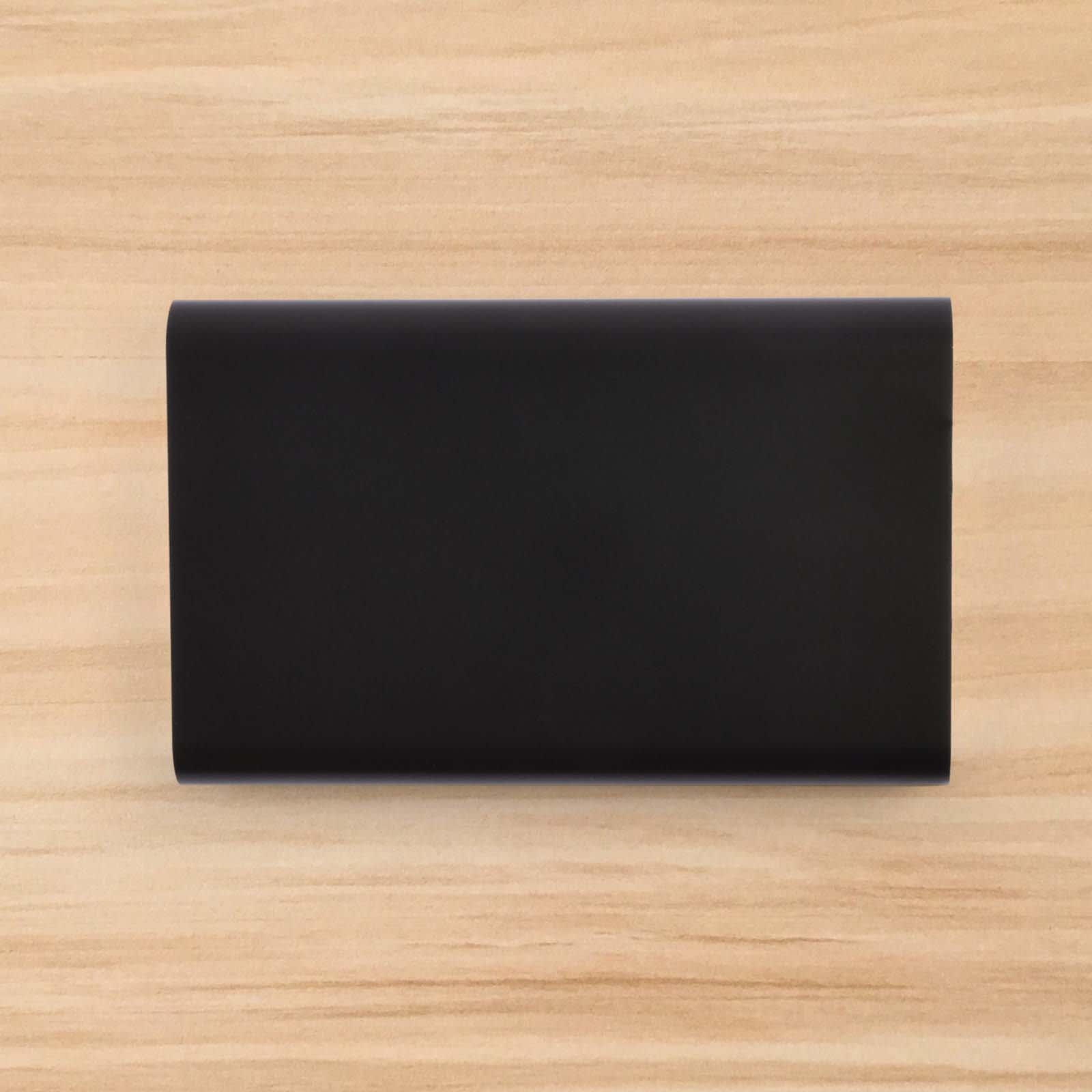 A sleek black Octavius 8,000mAh Power Bank is displayed on a wooden surface.