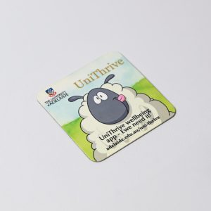 A square fridge magnet featuring a cartoon sheep and a logo, with a light background and rounded corners.