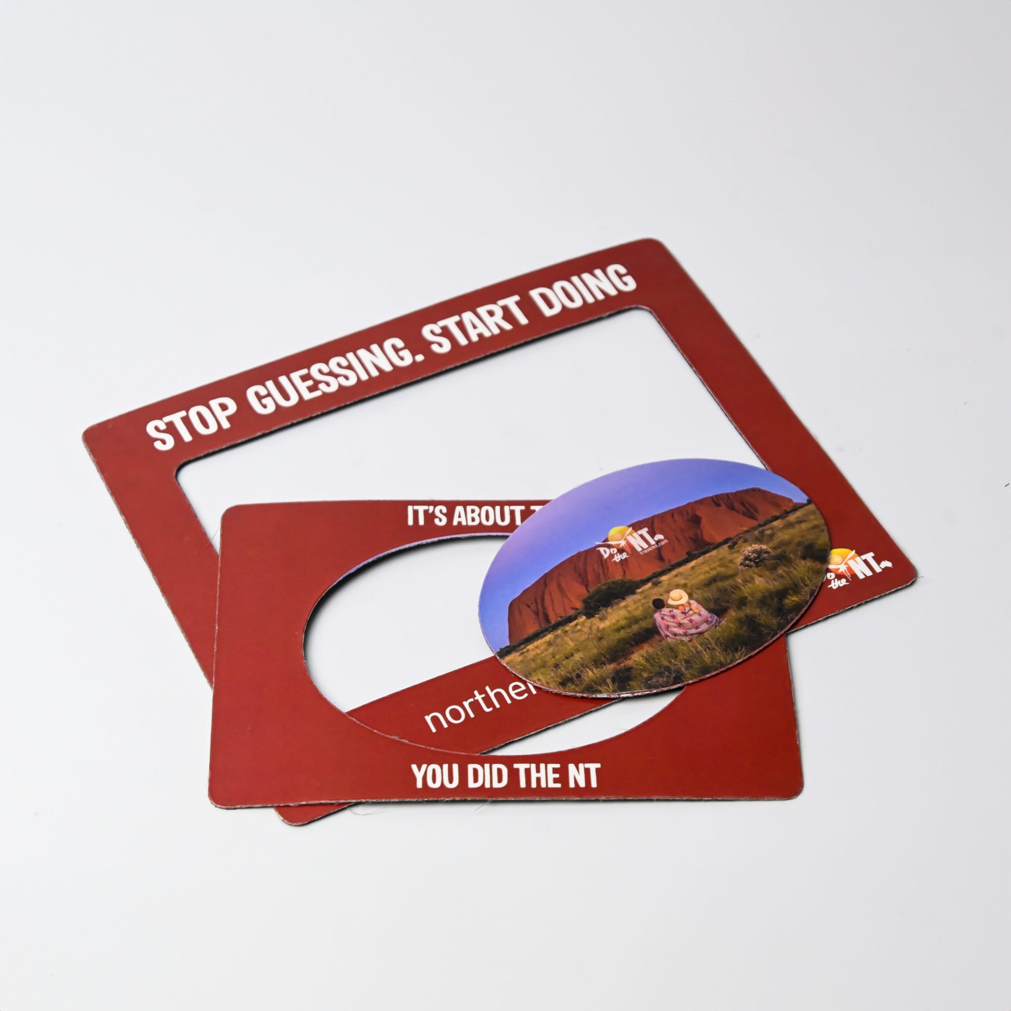A magnetic photo frame set in a rich red colour, featuring a circular insert and a logo.