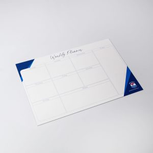 A magnetic whiteboard in white and blue, featuring a weekly planner layout with multiple sections.