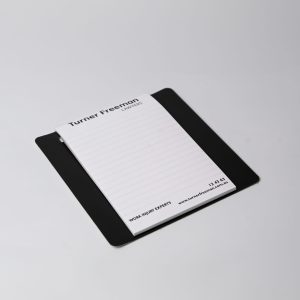 A magnetic whiteboard notepad in white, featuring a clip-on pen and an Australian Red Cross logo.