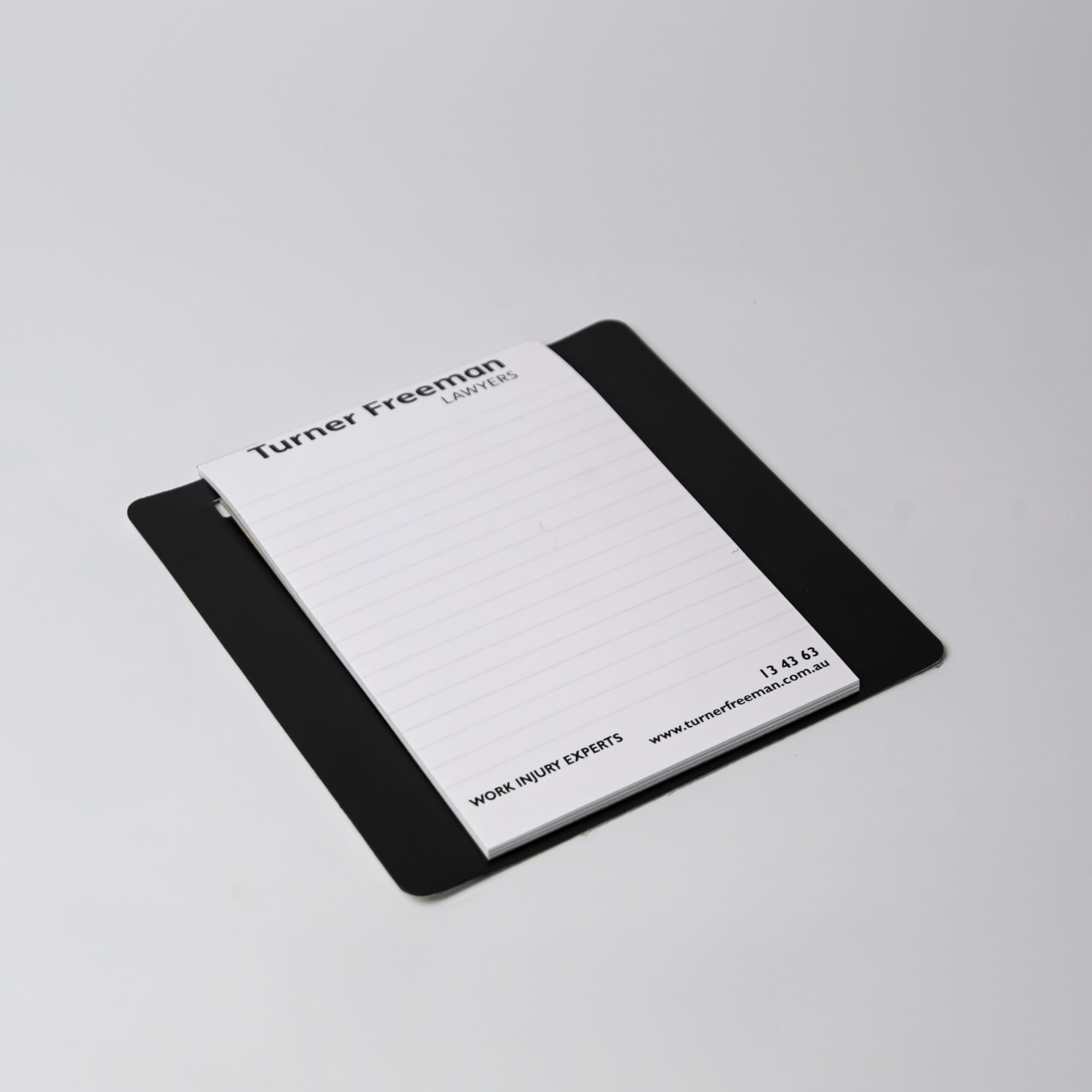 A magnetic whiteboard notepad in white, featuring a clip-on pen and an Australian Red Cross logo.