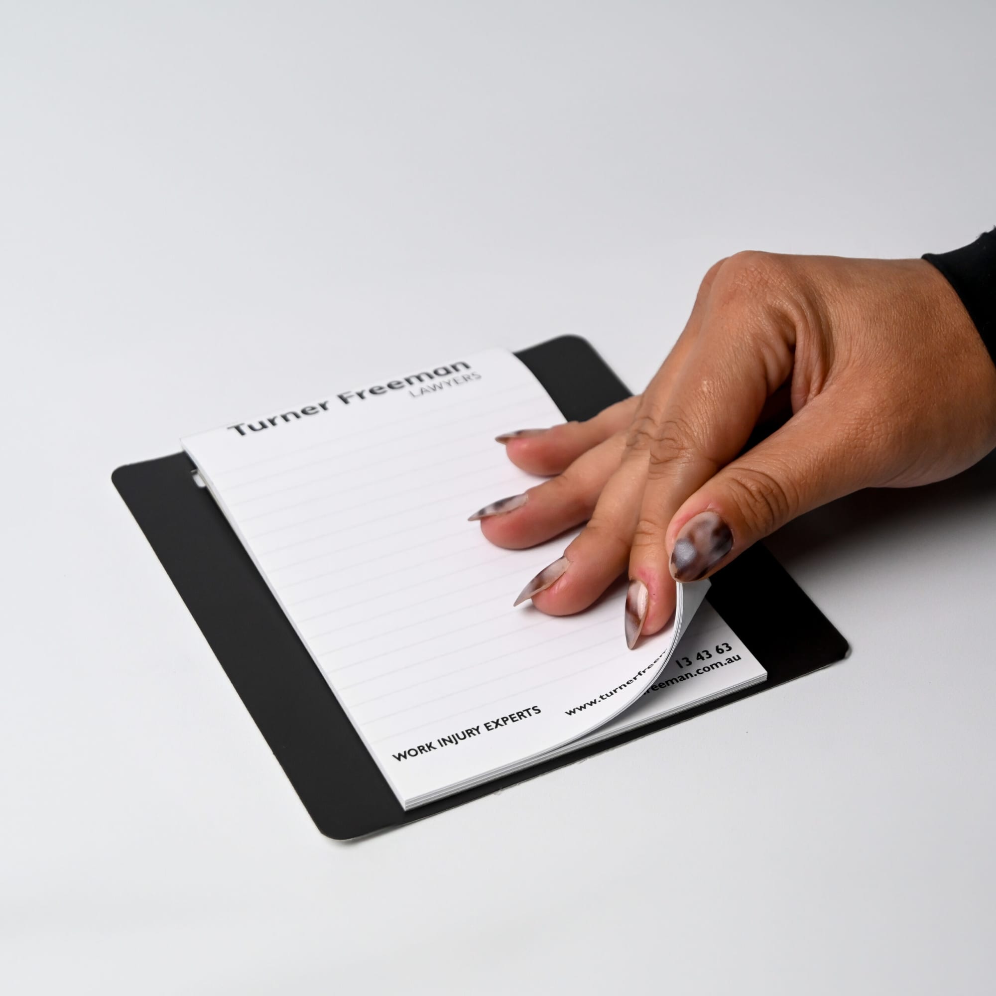 A magnetic whiteboard to-do list in white with a black pen and a note pad, featuring a logo in the corner.