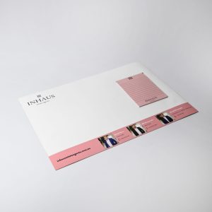 A3 magnetic whiteboard in white featuring a pink notepad, with a logo and branding on the bottom section.