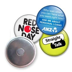 A collection of four button badges featuring various colours, designs, and a metallic backing.