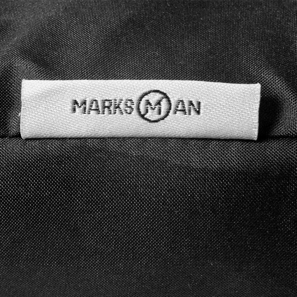 A close-up of a black fabric with a branded tag featuring the name 
