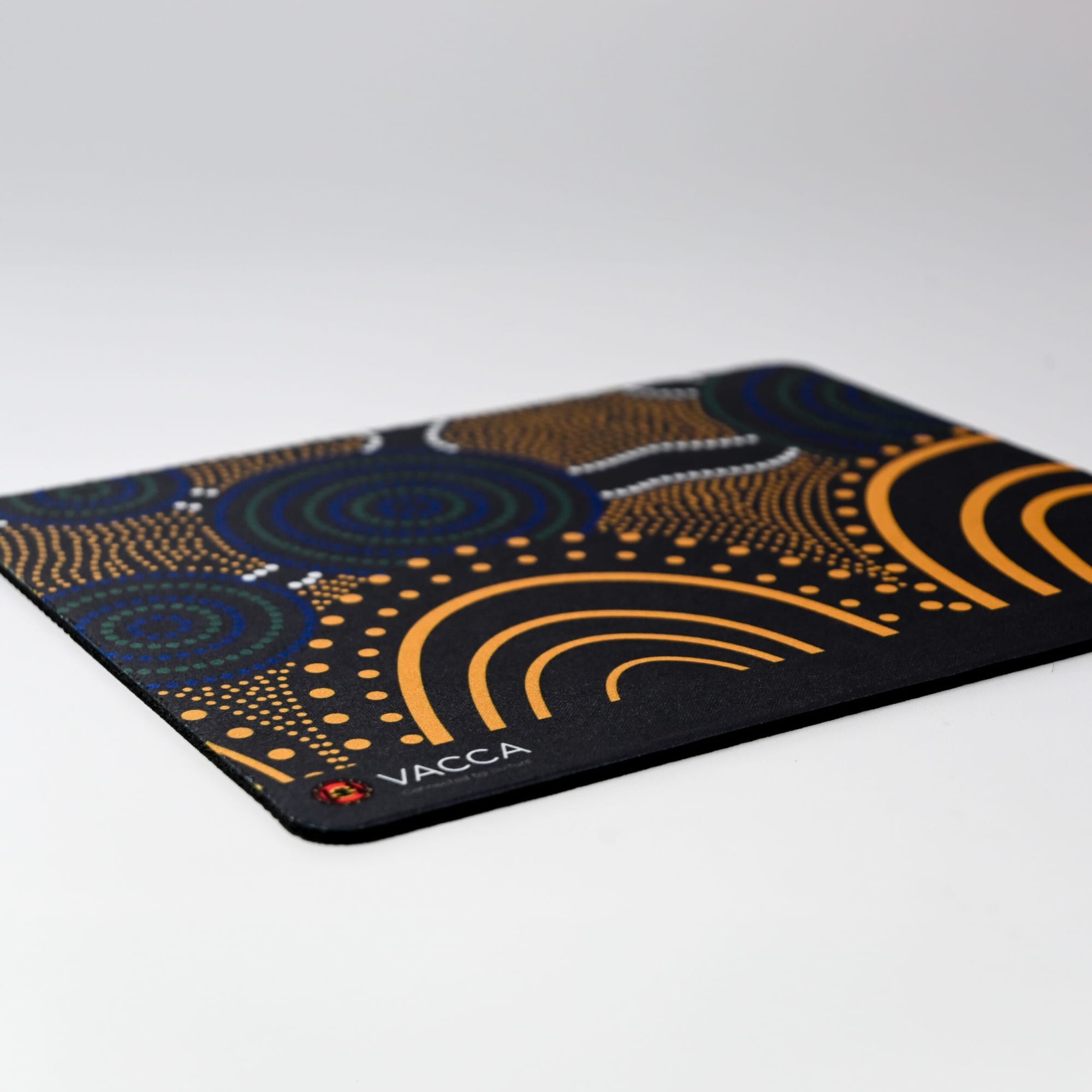 A patterned mouse mat featuring blue, orange, and black colours with a logo in one corner.