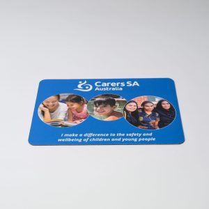 A blue mouse mat featuring images of children and young people, with a logo and text promoting safety and wellbeing.