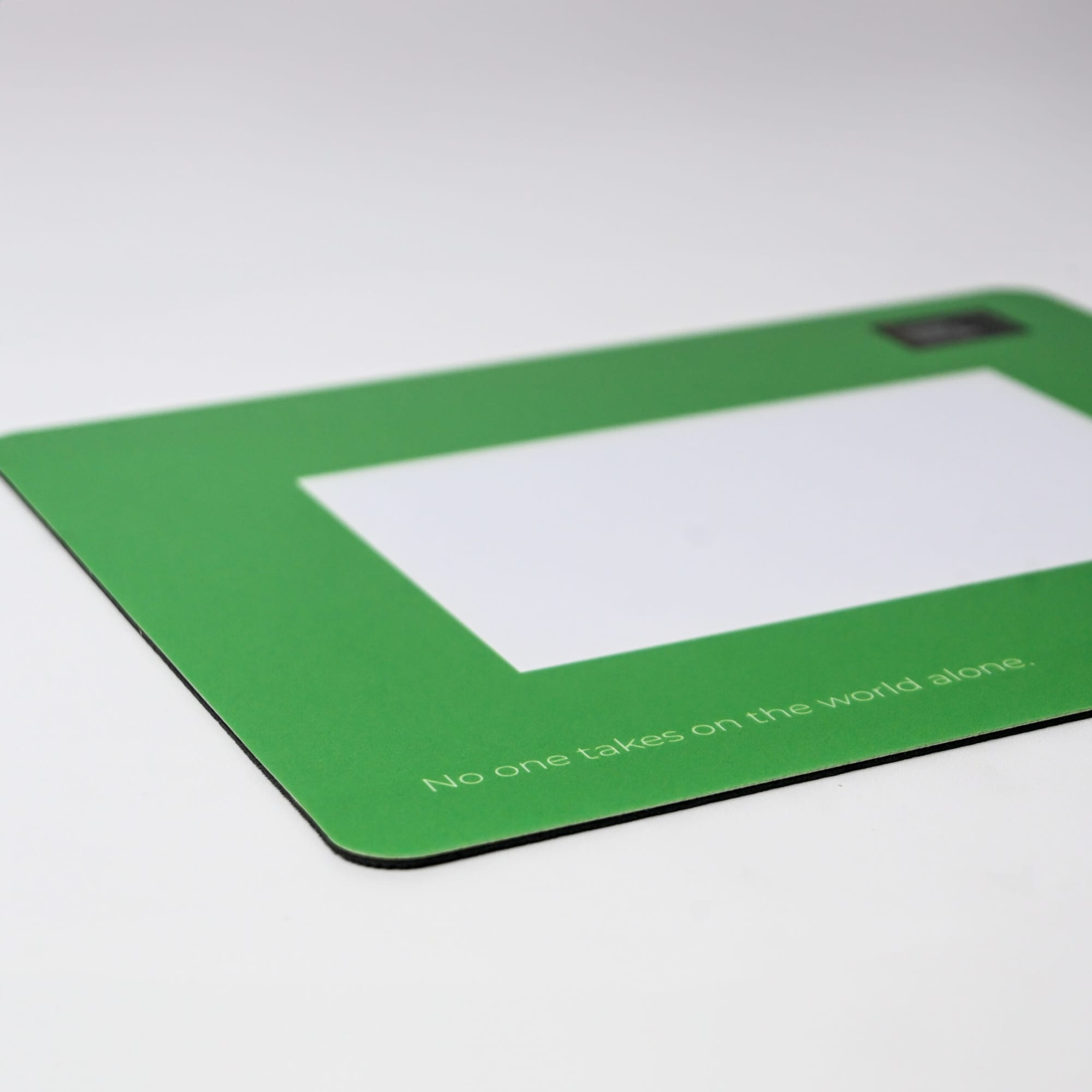 A green mouse mat featuring a blank photo frame area and a logo in the corner.