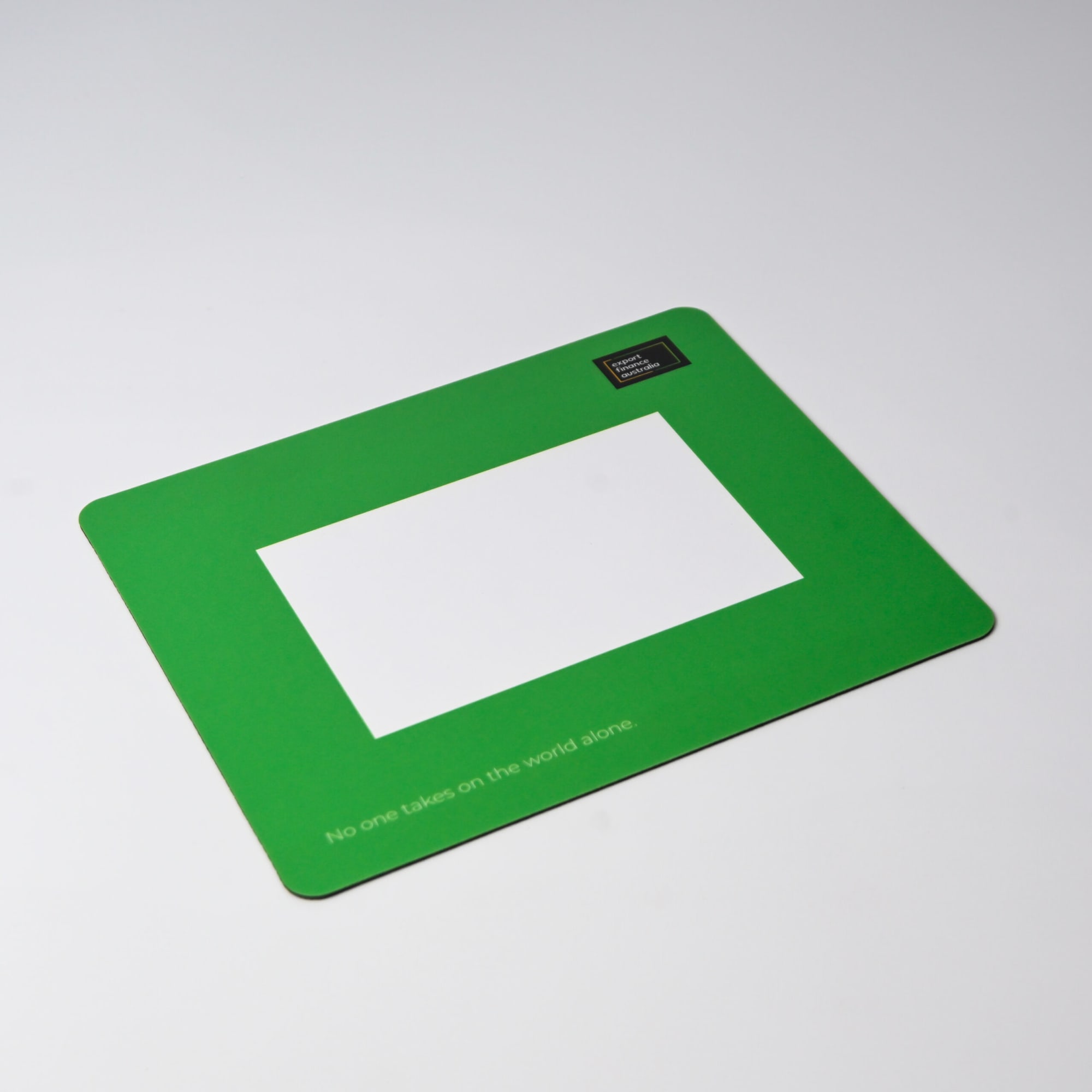 A green mouse mat featuring a central photo frame cut-out and a logo in one corner.